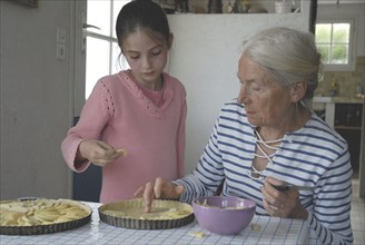 Girl making pastry with her grandmother