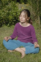 Fillette de 9ans faisant du yoga dans jardin