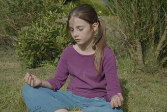 Fillette de 9 ans faisant du yoga dans jardin