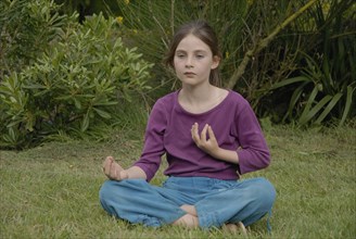 Fillette de 9 ans faisant du yoga dans un jardin