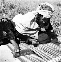 Femme nomade tissant, à Laghouat, en Algérie