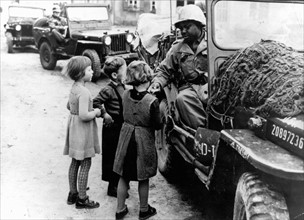 A G.I. gives chocolate to children