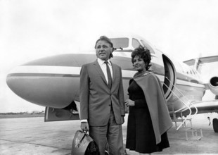 Elizabeth TAYLOR with Richard BURTON in front of plane, 1967