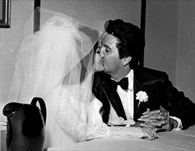 Elvis Presley and Priscilla Presley kissing at their wedding