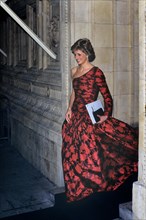 A smiling "Diana Princess of Wales"  wearing a red and black dress leaving the Royal Albert Hall in London 18th October 1989