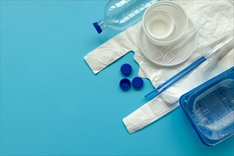 Plastic packages on blue background. Copy space. Top view. Eco and save earth concept.