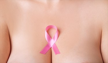 Nude woman breast with pink ribbon. Breast cancer symbol