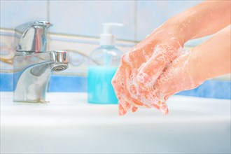 Washing hands with soap and water. Hands over sink with soap. Protective measures against coronavirus COVID-19 disease. Cleaning hands, washing hands