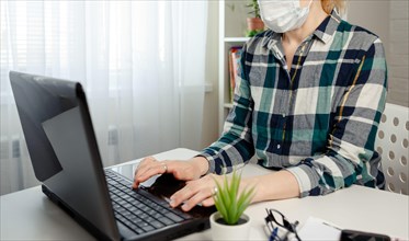 Woman in medical mask working office work remotely from home