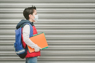covid-19,kid with medical mask and backpack who walks to school outdoor
