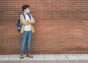 kid with medical mask and backpack going to school outdoor