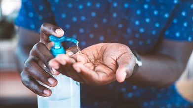 African man cleaning hands with sanitizer gel for protect coronavirus or covid-19