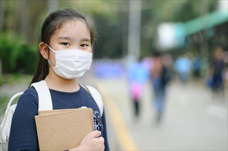 Back to school. asian child girl wearing face mask with backpack  going to school .Covid-19 coronavirus pandemic.New normal lifestyle.Education concep