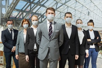 Business people wearing surgical protective masks and standing together, healthcare and covid-19 prevention concept