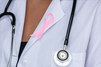 close-up of Doctor with ribbon formed breast cancer awareness symbol
