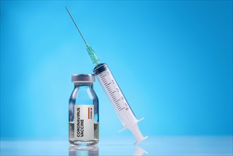Coronavirus Vaccine / Corona virus Vaccine concept with Vial and Syringe on blue background