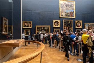 Tourists queuing to take pictures of the Mona Lisa painting by italian artist Leonardo da Vinci at the Louvre Museum in Paris, France, Europe