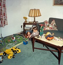 Boy playing with his new train set at Christmas, c. 1960