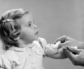 1960s 1960s LITTLE GIRL GETTING SHOT HYPODERMIC NEEDLE VACCINATION INJECTION IMMUNIZATION VACCINE