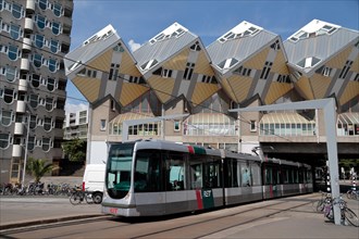 Tram passing under the Cube houses (Kubuswoningen) designed by Piet Blom, Rotterdam, Netherlands.