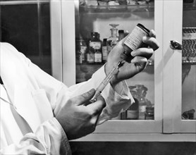 Centers for Disease Control (CDC) laboratorian filling a syringe with rabies vaccine, 1968. Image courtesy Centers for Disease Control. ()