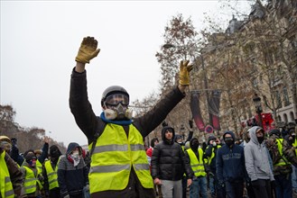 Champs-Elysees, Paris, France. 15th Dec 2018. Protestor wearing gas mask raises his hands to police. Yellow Vests (Gilets Jaunes) protests, Champs-Elysees, Paris, France, December 15, 2018. Credit: Ju...