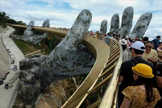 Da Nang, Vietnam - August 18, 2018: Tourists in the Golden Bridge. The Golden Bridge is a 150 m long pedestrian bridge in the Ba Na Hills in Da Nang.