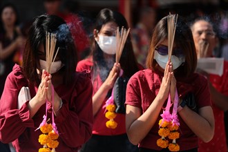 Women pray while wearing dust masks during the celebration at Leng Noei Yi Temple in Chinatown, Bangkok.The Lunar New Year, also known as Spring Festival in China marks the beginning of the Year of th...