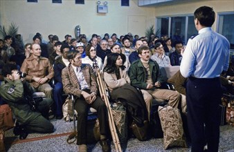 February 1979 - Evacuees from the US Embassy in Tehran, Iran, are briefed upon their arrival at the air base terminal.