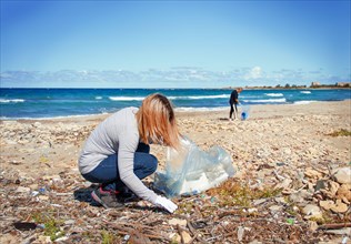 Volunteers cleaning beach area from  plastic