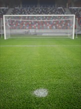 Shallow depth of field (selective focus) image with the penalty kick point on an empty soccer stadium.
