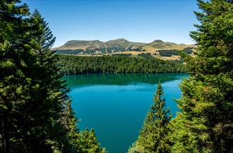View on Volcanic lake of Pavin located in the Regional Natural Park of Auvergne Volcanoes, Sancy massif in the background, Auvergne, France, Europe