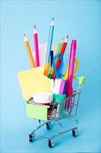 Concept of back to school. Shopping cart with school supplies