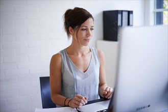 Mid adult woman working from home on computer