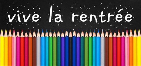 Vive la rentree (meaning Back to school) written on black chalkboard background with colorful wooden pencils