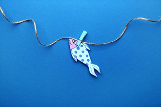 Paper fish on color background. April Fool's Day prank