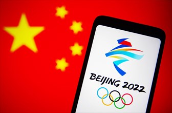Ukraine. 07th Dec, 2021. In this photo illustration, 2022 Winter Olympics (XXIV Olympic Winter Games or Beijing 2022) logo is seen on a smartphone screen with a flag of China in the background. Credit...