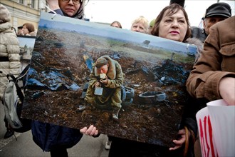 Moscow, Russia. 15th March, 2014 A woman holds a banner with a photo of Vladimir Vyatkin photographer at the action "One Second of War" as part of the Peace March along the boulevards of the central M...