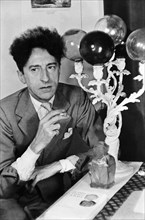 Portrait of Jean Cocteau, famous French artist and writer, smoking a cigarette.