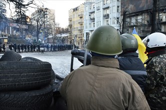 Kiev, Ukraine. 02nd Feb, 2014. Protesters look towards a line of police from behind their makeshift barricade. The so-called EuroMaidan demonstrations began after plans for closer integration with Eur...