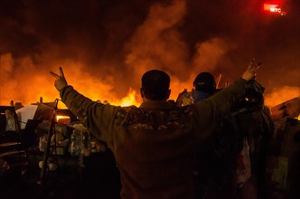 Feb. 20, 2014 - Kiev, Ukraine- February 20, 2014: Midnight on the Maidan, protesters at the barricades singing the Anthem of Ukraine. A barricade is created by protesters made of burning objects. More...