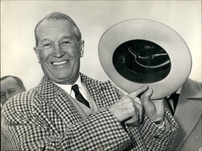 Nov. 11, 1959 - Maurice Chevalier swops boater for Cowboy hat. Back from Hollywood Maurice Chevalier arrived at Orly Airport this afternoon. OPS: Maurice showing the cowboy hat he brought from Califor...