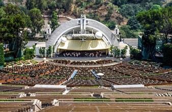 An orchestra rehearses on stage before 17,376 sloping empty seats in the famed Hollywood Bowl that is named for a natural amphitheater created by the Hollywood Hills in Hollywood, California, USA. An ...