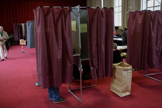 Paris, France. 7th May 2017. A voter makes his decision inside the voting booth. Around 47 Million French people are called to the ballot boxes to elect the next President of France. The independent c...