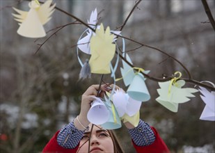 Kyiv, Ukraine. 20th Feb, 2018. A girl hangs the paper cuted angel at a tree near the place where people were killed during the revolution. Ukraine pays tribute to the victims of the 2013-2014 anti-gov...