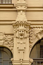 Art deco decoratio with a screaming crowned man`s head abstract flowers, found on the facade of a Jugendstil building in riga, Latvia