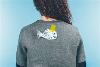 back view of woman with hand drawn fish on back, april fools day concept