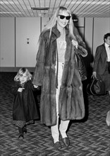 Model and wife of Rolling stone Mick Jagger, Jerry Hall arriving at London's Heathrow Airport with daughter Elizabeth Scarlett in March 1987.