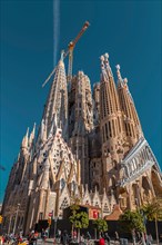 Barcelona, Spain - February 9, 2022: Exterior view of La Sagrada Familia, a large unfinished minor basilica in the Eixample district of Barcelona, Cat