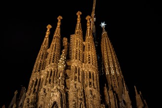 Façana del Naixement (Facade of the Birth) and the star of the Mary tower illuminated at night in the Sagrada Familia (Barcelona, Catalonia, Spain)